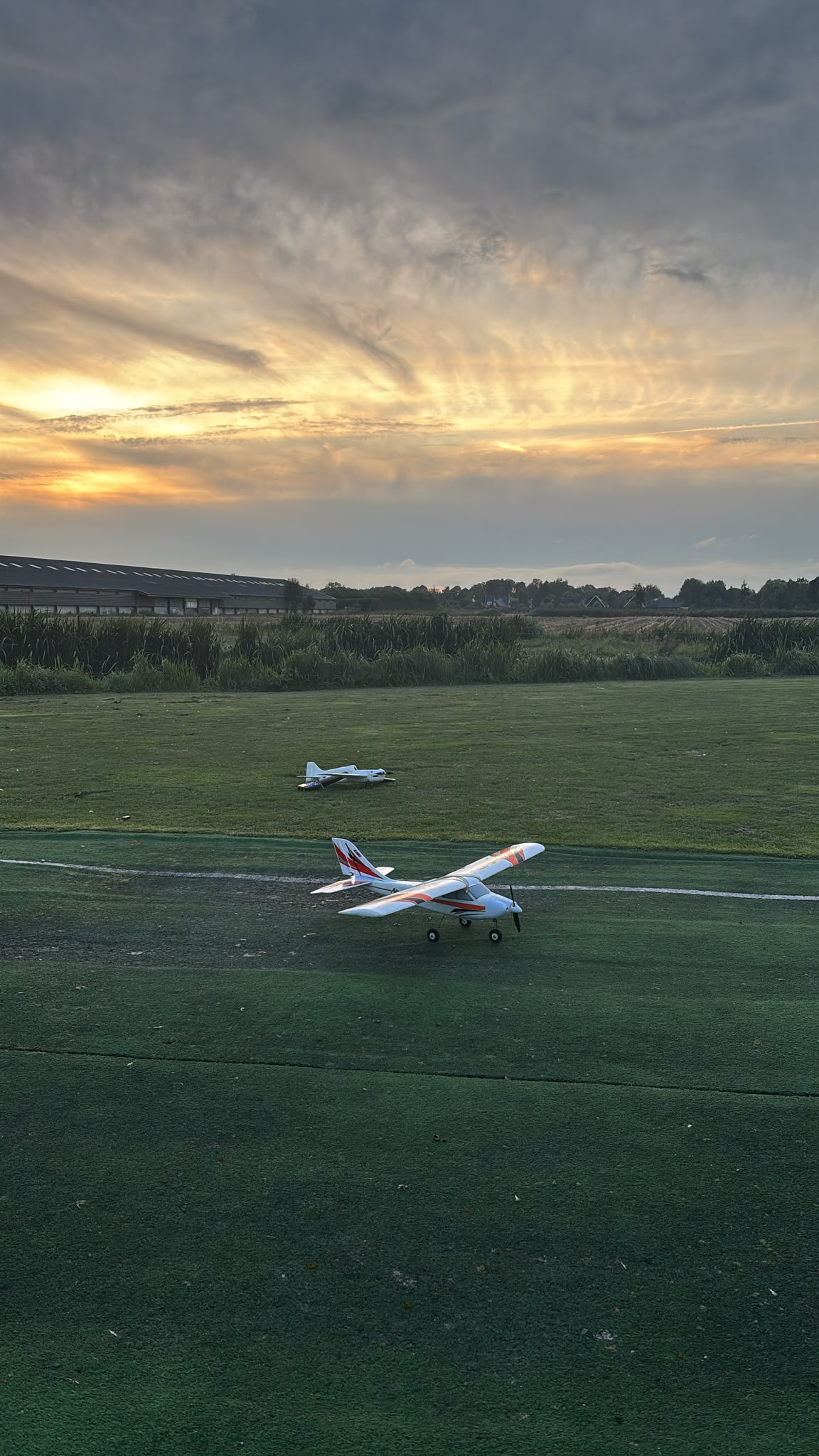 Modelvliegtuigen op het veld bij zonsondergang